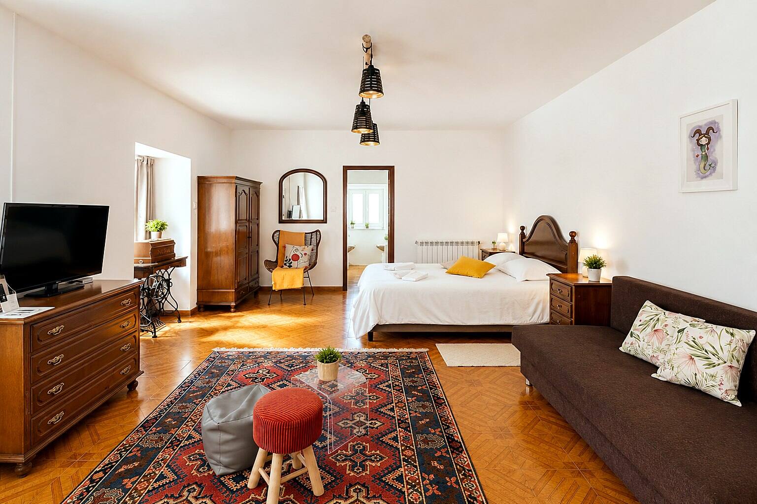 Chambre-séjour d'Outeiro 1 : lit double, canapé, tapis et parquet — Casa Outeiro 99, Paredes de Coura