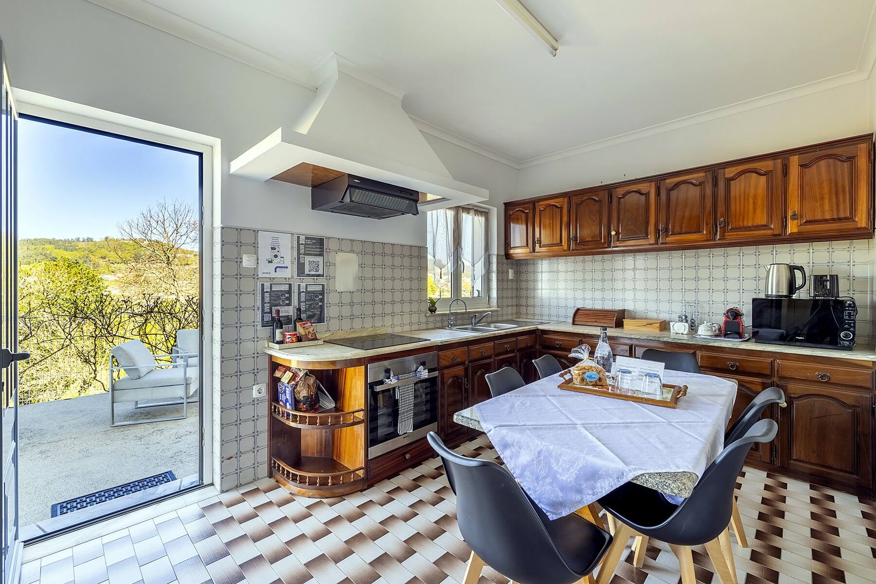 Cuisine d'Outeiro 2 avec table à manger et porte sur la terrasse — Casa Outeiro 99, Paredes de Coura